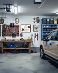 Bloodhound-Heritage History Dog Breed Portrait in Garage with workbench, tools, and K9 Unit vehicle