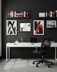 Modern office setup with a white desk, black chair, and decorative elements and a Dalmatian-Heritage History Dog Breed Portrait on a grey wall.