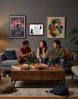 Three friends sitting on a couch in a living room with pizzas and drinks, surrounded by a Doberman Pinscher-Heritage History Dog Breed Portrait on the wall.