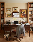 Home office with wooden desk, bookshelves, and Basset Hound-Heritage History Dog Breed Portrait on the wall